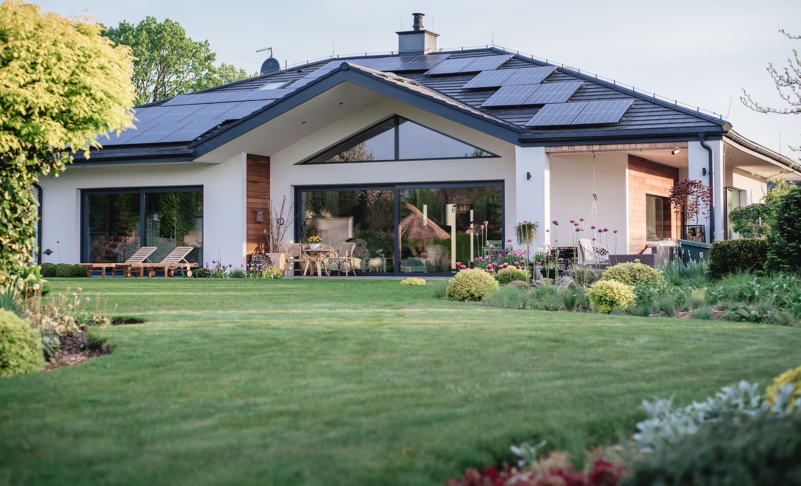 Modern house with a wide glazed garden elevation, the type of south-facing opening that needs external solar shading